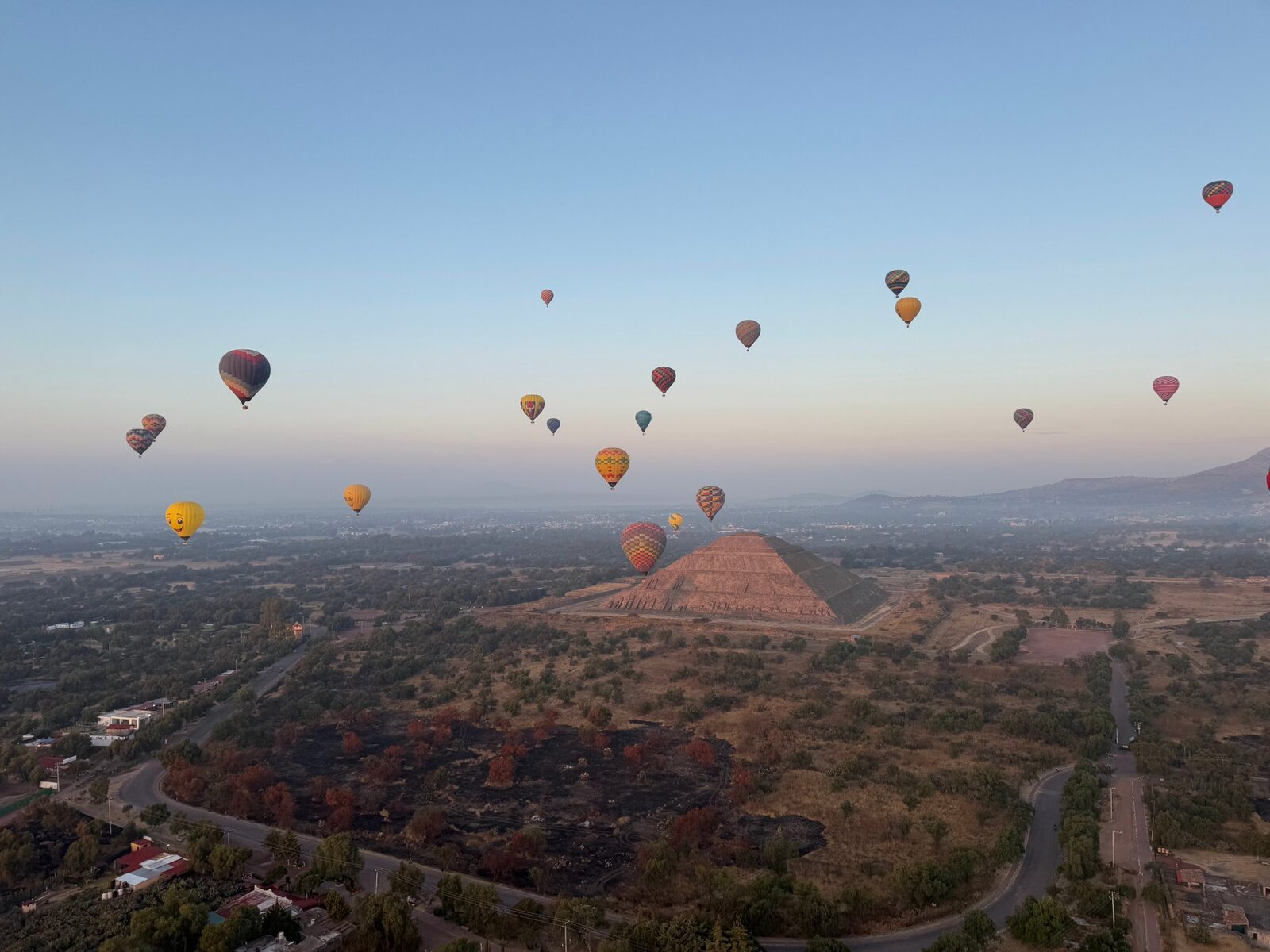 Hot air balloons drifting over the Pyramid of the Sun at Teotihuacan at dawn