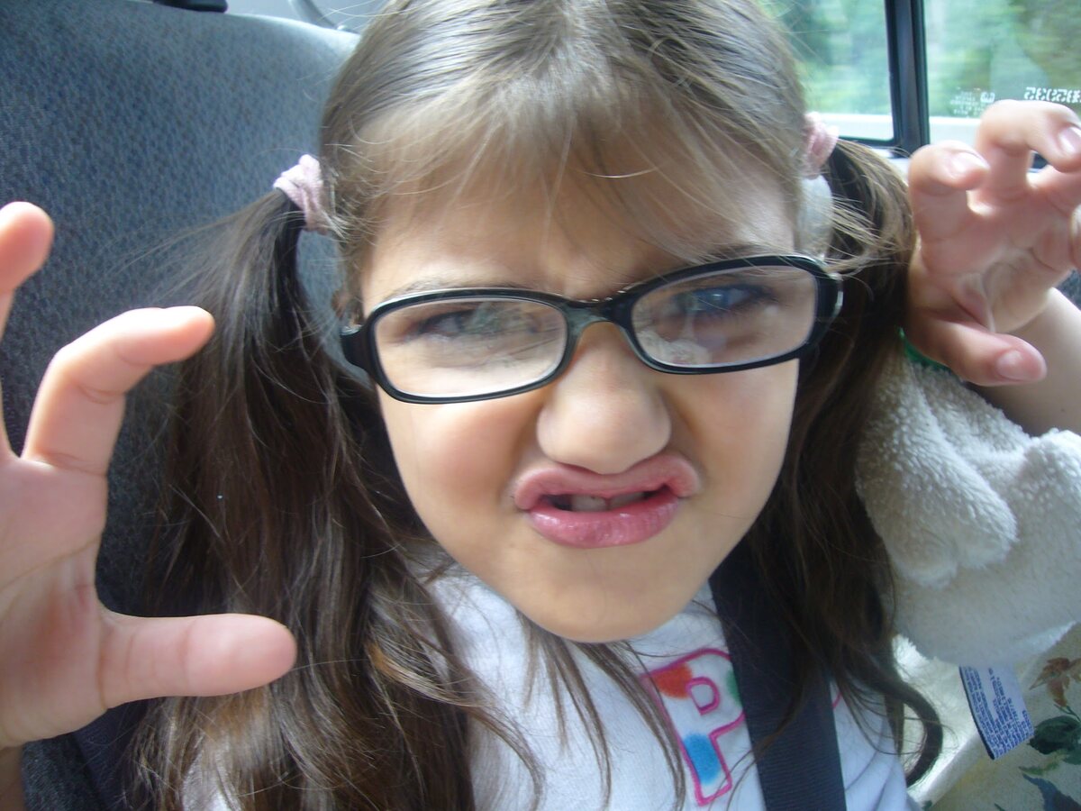 Radhika as a kid in pigtails and glasses, claws up, mid-growl